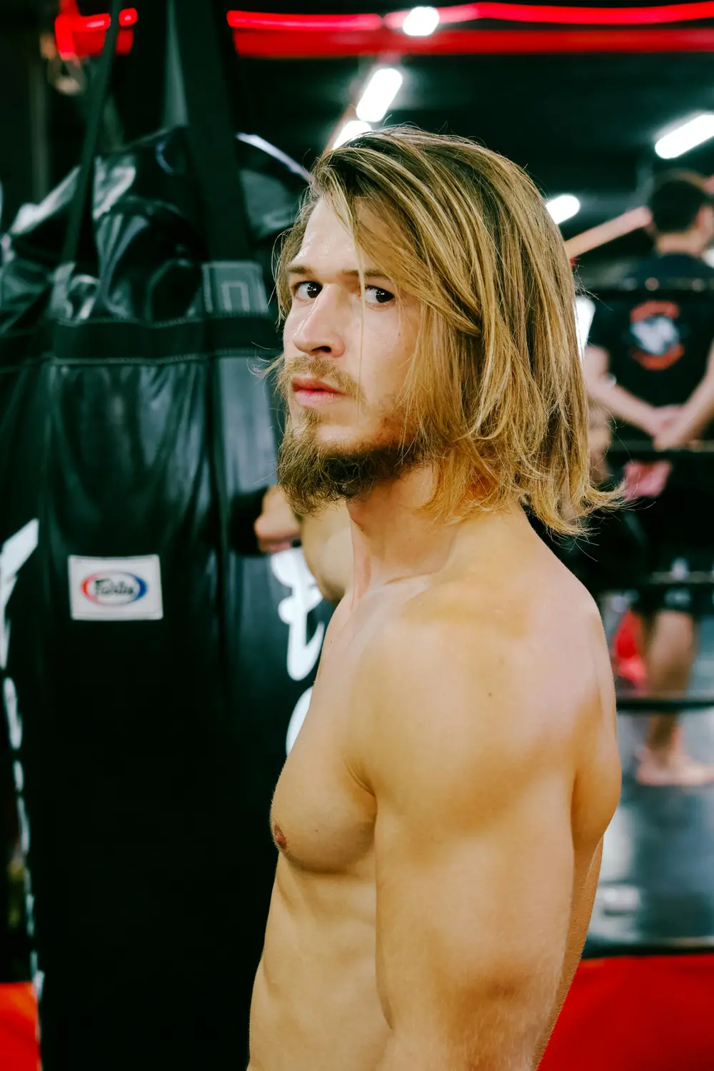 Boxeador entrenando junto a los sacos pesados en el gimnasio del club
