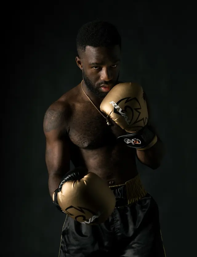 Retrato de Rubén Casares con guantes de boxeo dorados en posición de guardia