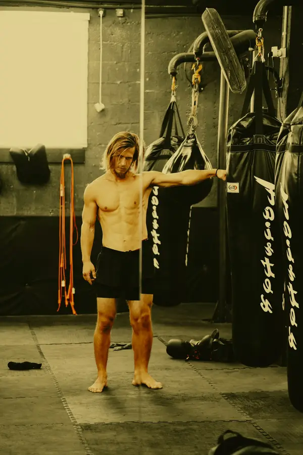 Zona de sacos de boxeo con cuerdas de saltar colgadas en la pared