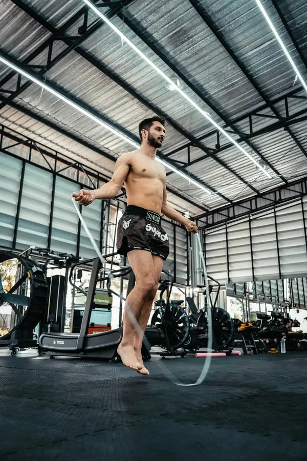 Boxeador saltando la cuerda en la zona de acondicionamiento del gimnasio