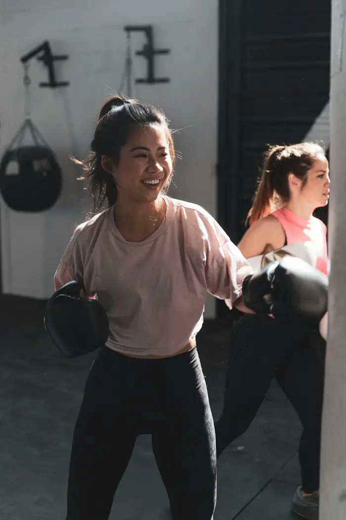Grupo de personas entrenando con guantes de boxeo en un circuito de acondicionamiento